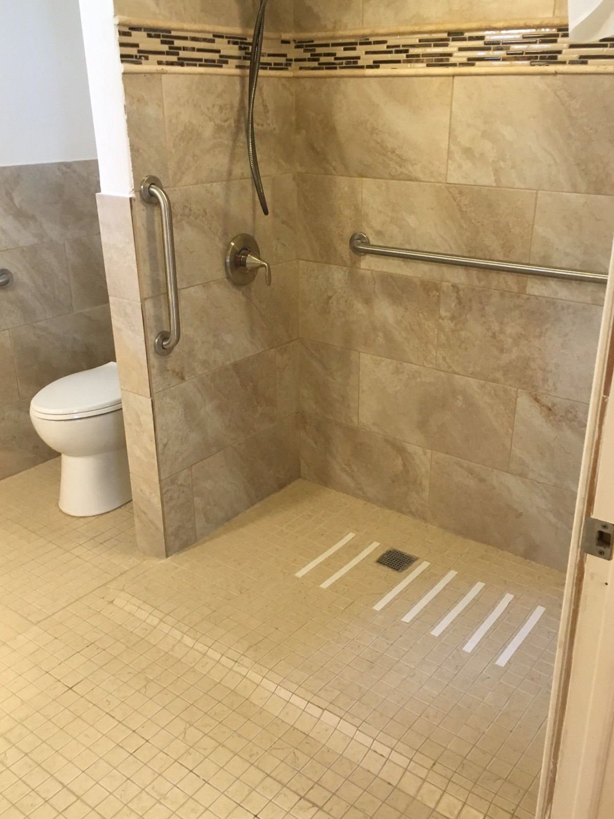 Accessible bathroom with walk-in shower and grab bars.