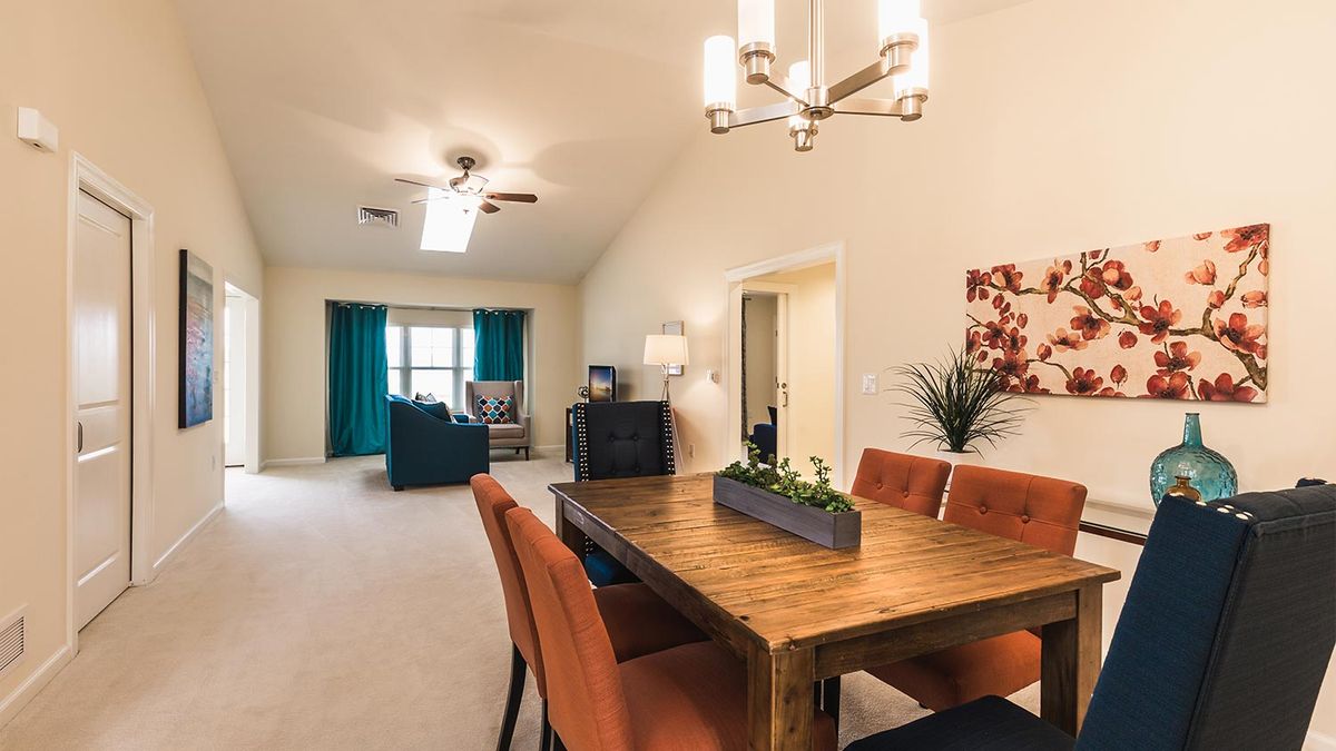 Modern open-plan dining and living area with stylish furniture and bright lighting.