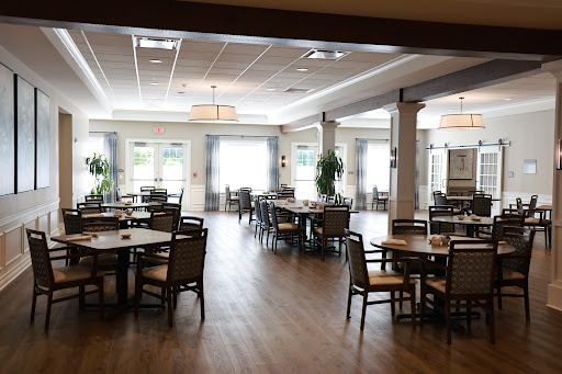 A spacious and modern dining area with neatly arranged tables and chairs, filled with natural light.