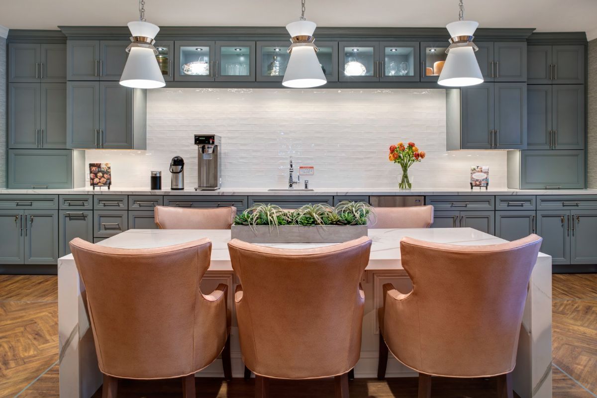 A modern kitchen with stylish pendant lights and comfortable seating.