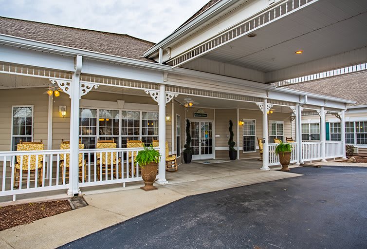 A view of a building entrance with a covered porch and decorative railing.