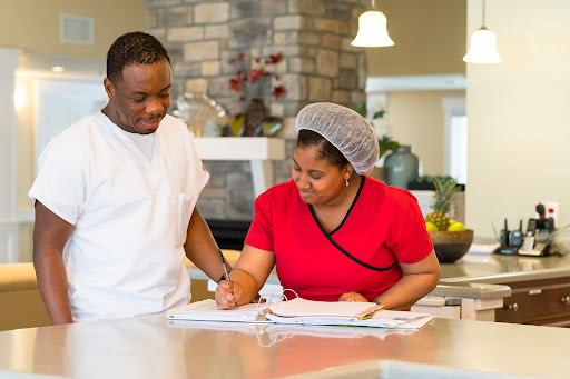 A chef and a staff member reviewing cooking notes in a modern kitchen.