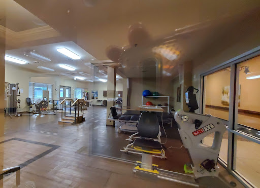 A view of a rehabilitation space equipped with various exercise tools and facilities for physical therapy.