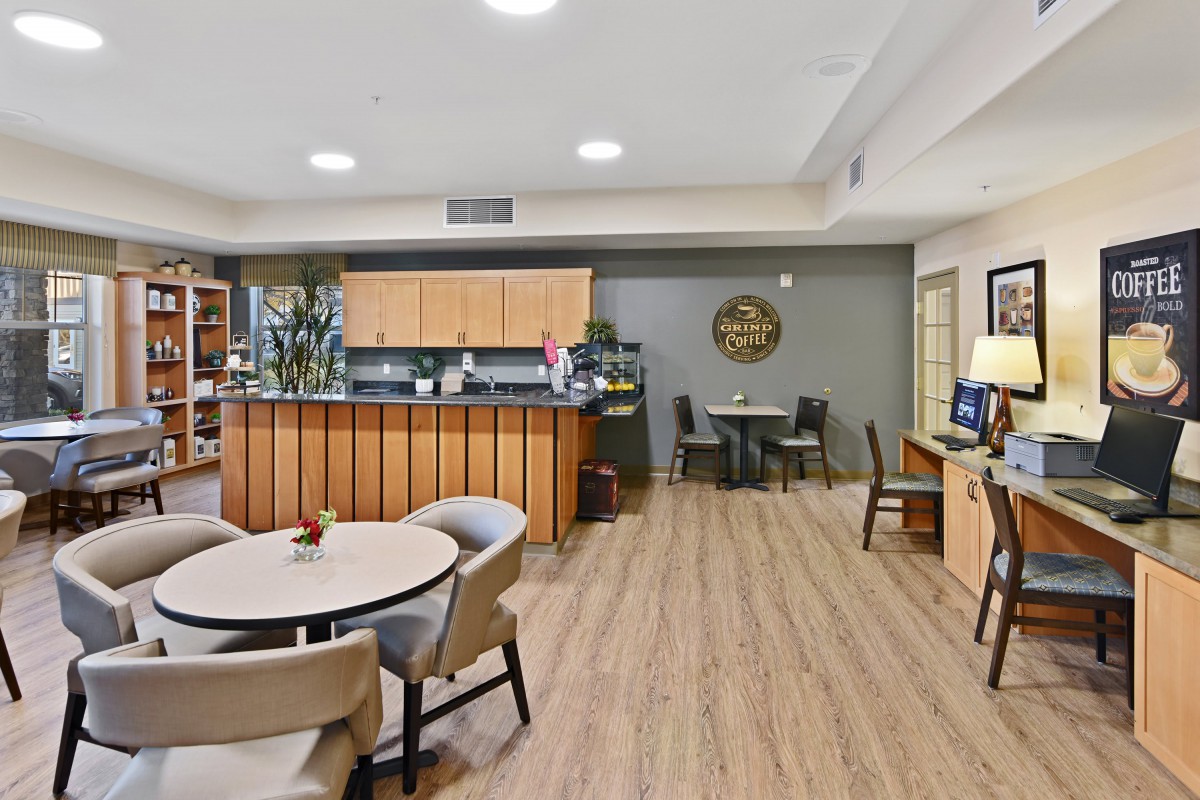 A modern cafe interior featuring comfortable seating and wooden flooring.