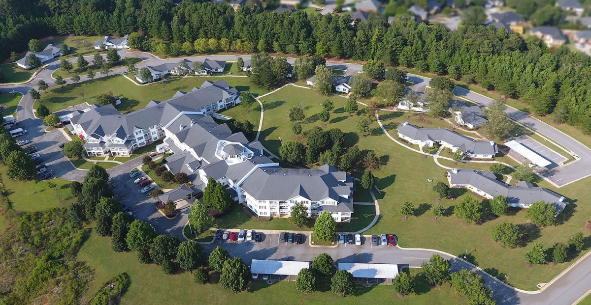 An aerial view of a large residential complex surrounded by greenery and trees.