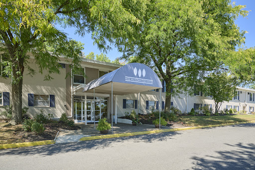 A welcoming entrance to a facility surrounded by lush greenery.