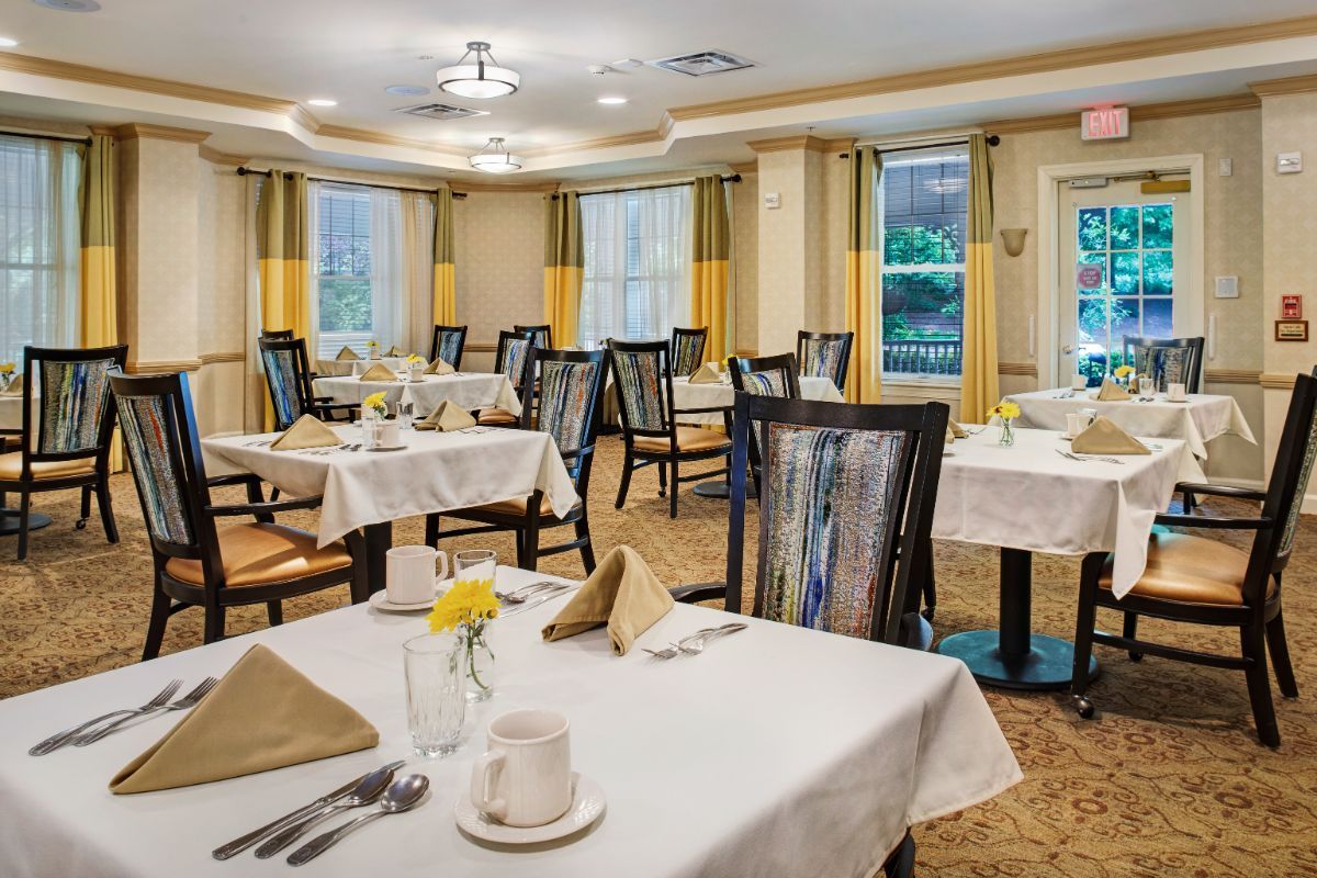 An elegantly set dining room with neatly arranged tables and chairs.