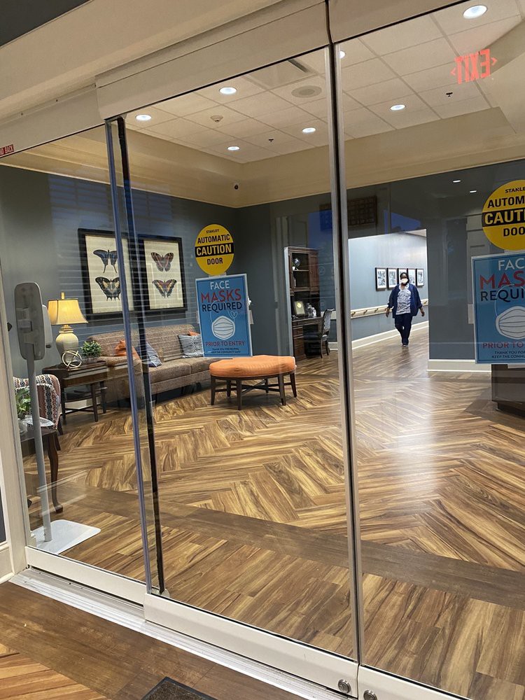 A welcoming lobby area with seating and decorative elements behind glass doors.