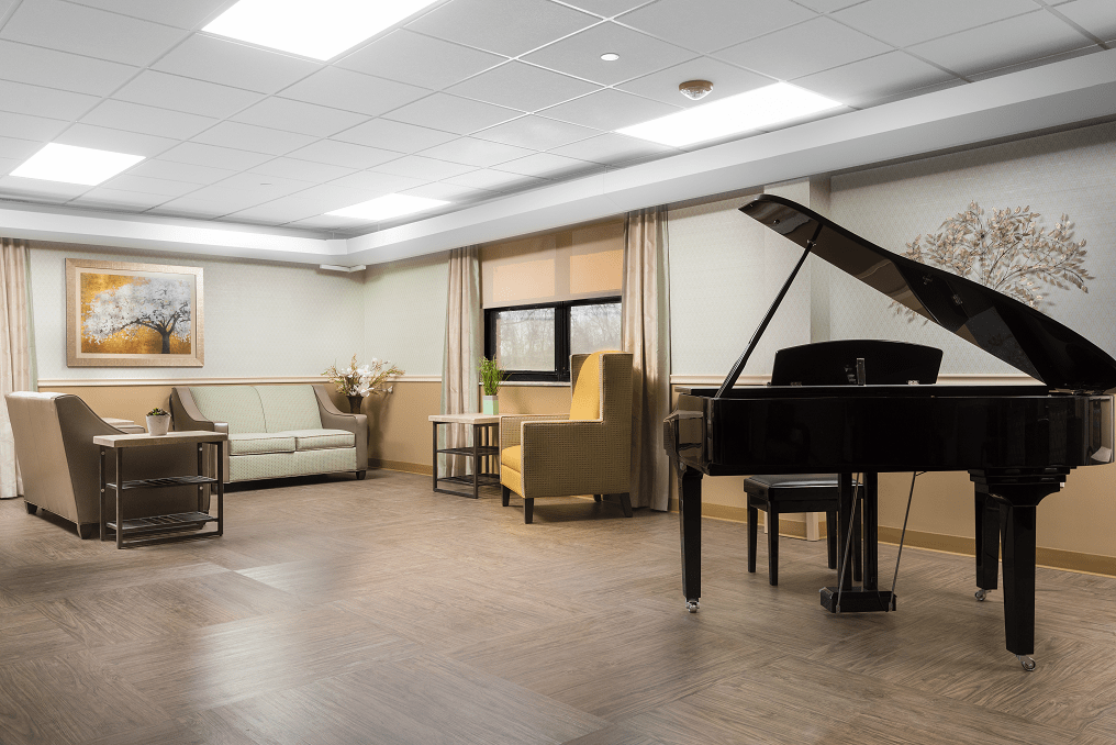 A modern lounge with a grand piano and comfortable seating.