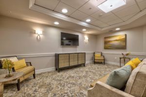 A cozy living room with modern furniture and a mounted television.