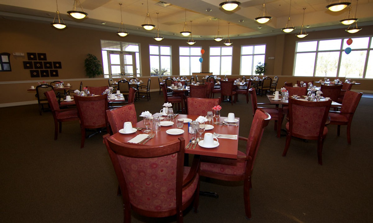 A spacious dining room with multiple tables set for guests.