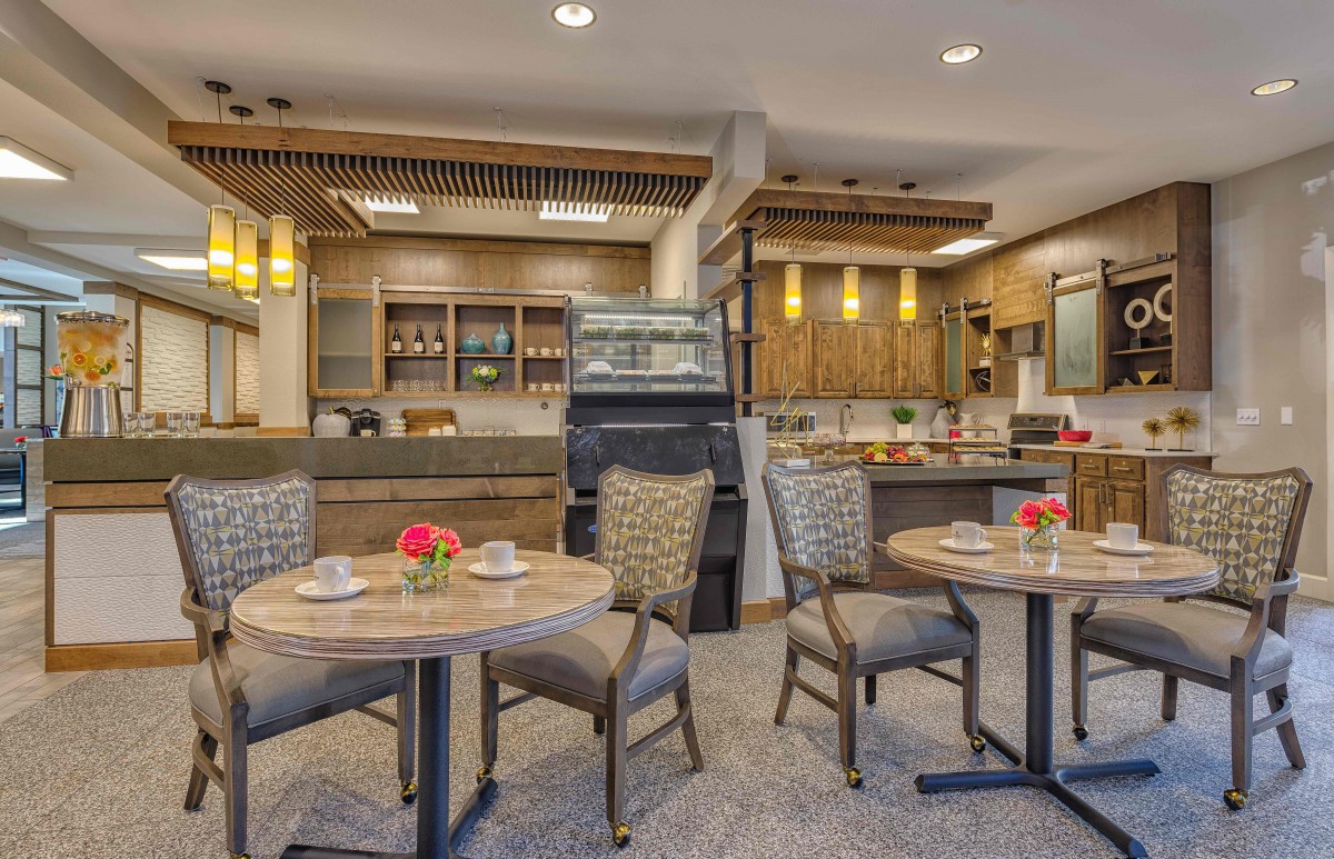A cozy and modern dining area with tables and chairs in a cafe or restaurant setting.