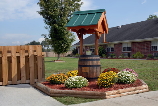 A charming garden well surrounded by vibrant flowers, adding a decorative touch to the outdoor space.