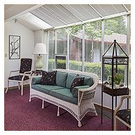 A cozy sunroom with wicker furniture and large windows allowing natural light to fill the space.
