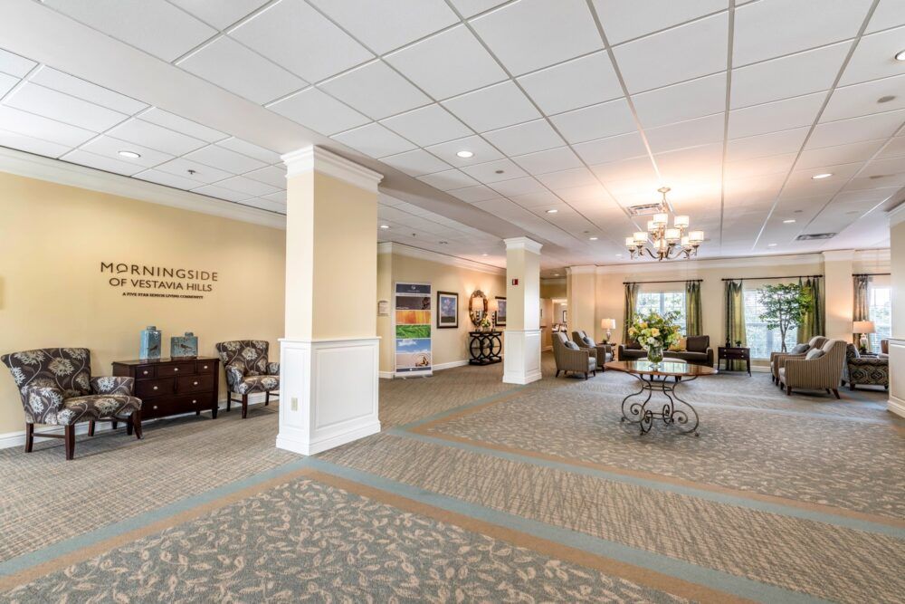 A spacious and elegantly decorated lobby with comfortable seating areas, a chandelier, and art on the walls.