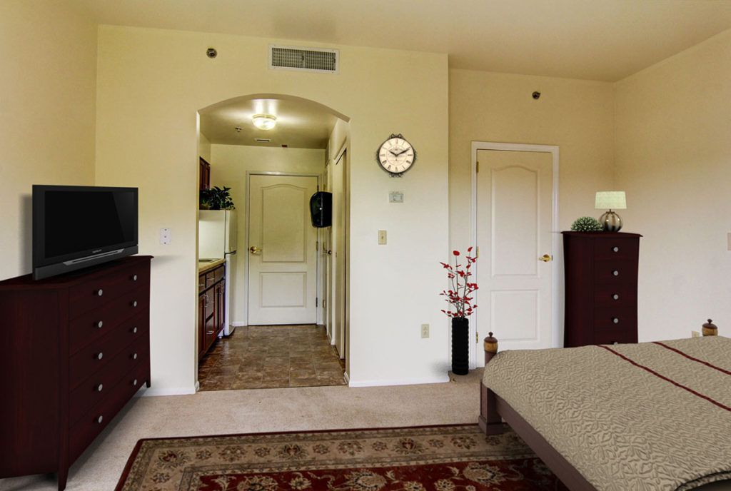 A modern bedroom with a view into an adjacent hallway, featuring stylish furniture and decor.