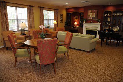 A cozy living room with a dining area, featuring comfortable seating, a fireplace, and warm lighting.