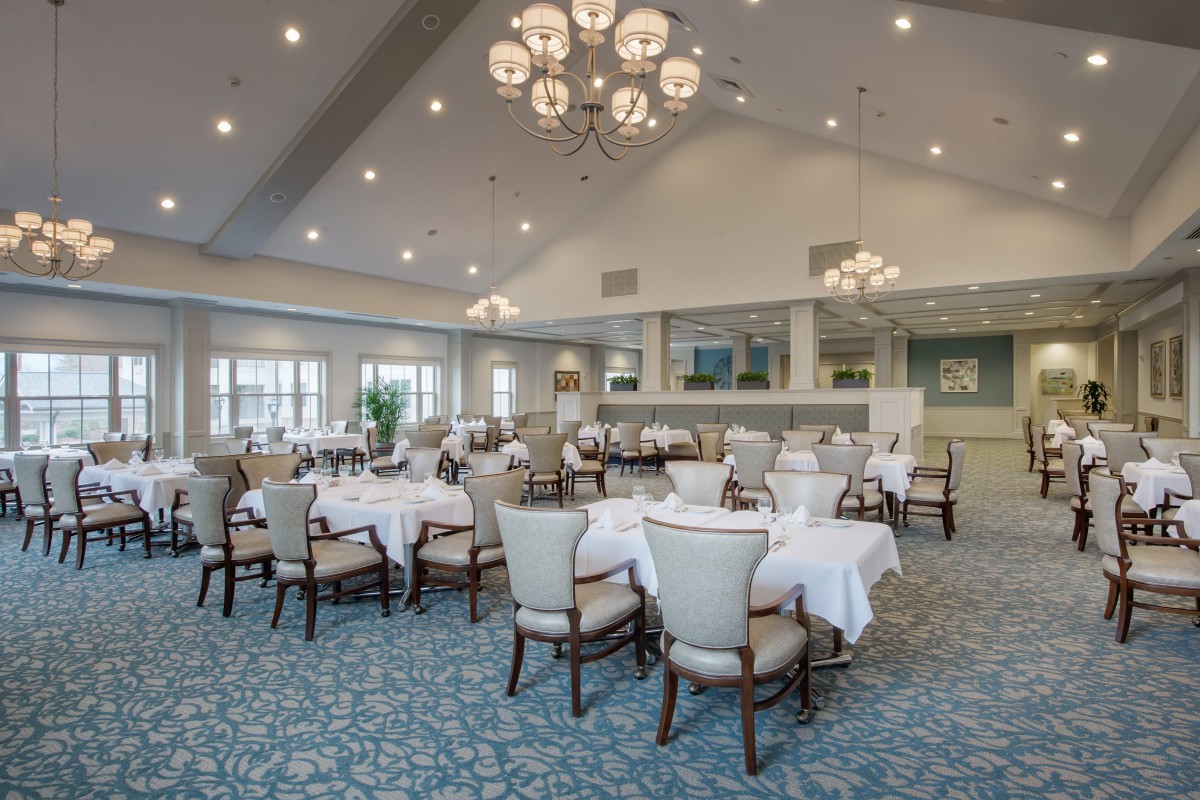 Elegant dining room with chandeliers and neatly arranged tables.