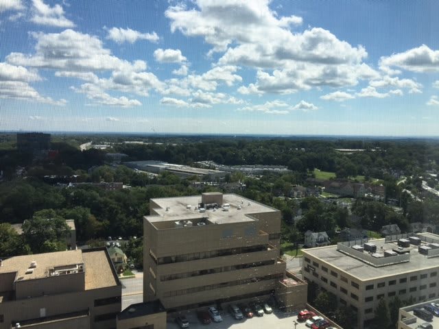 Aerial view of city buildings under a partly cloudy sky.
