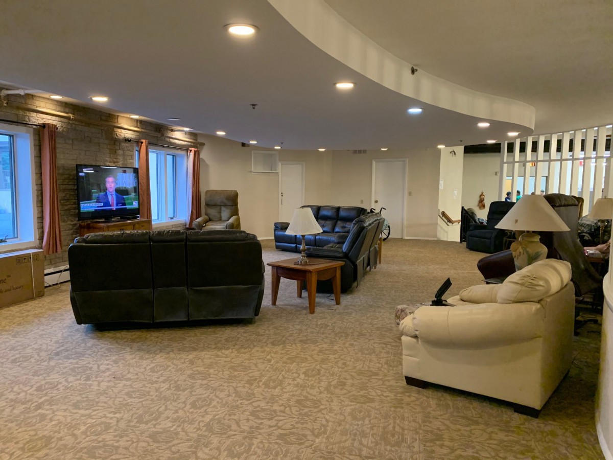 A spacious basement living room with comfortable seating and a TV.