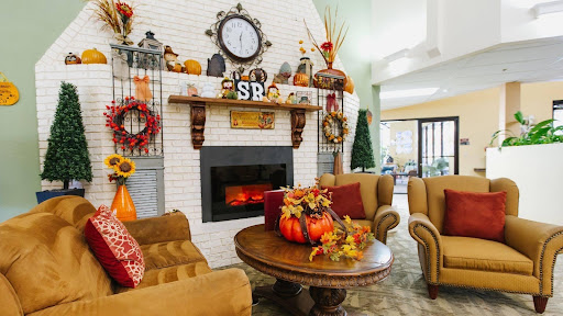 A cozy living room decorated for autumn, featuring a warm fireplace and seasonal elements.