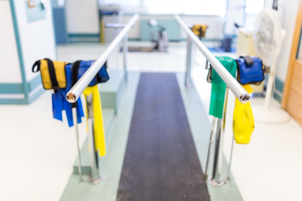 A rehabilitation setup featuring parallel bars and resistance bands in a physical therapy center.