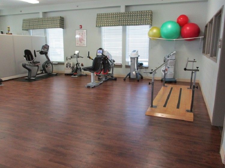 A gym with various exercise equipment and colorful exercise balls.