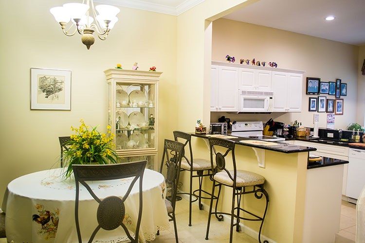 Cozy dining area adjacent to a kitchen with bar stools and elegant decor.