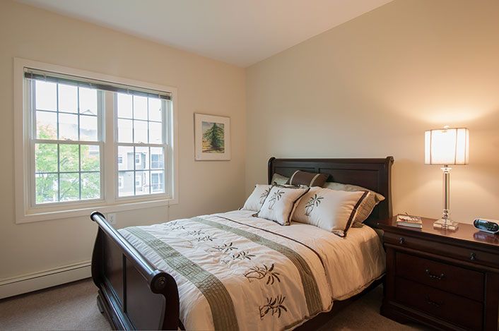 A cozy bedroom with a neatly made bed and soft lighting.
