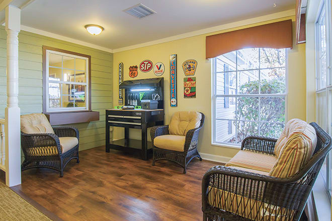 A cozy living room with wicker furniture, a fish tank, and decorative wall art.