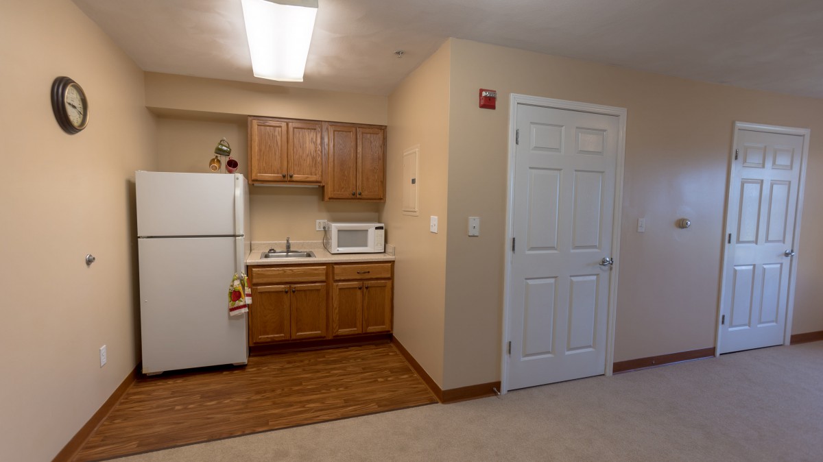 A compact kitchenette area in an apartment with essential appliances.