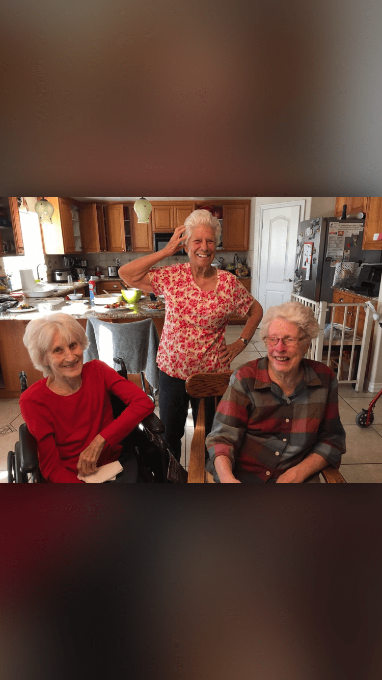 Three seniors enjoying time together in a kitchen setting.