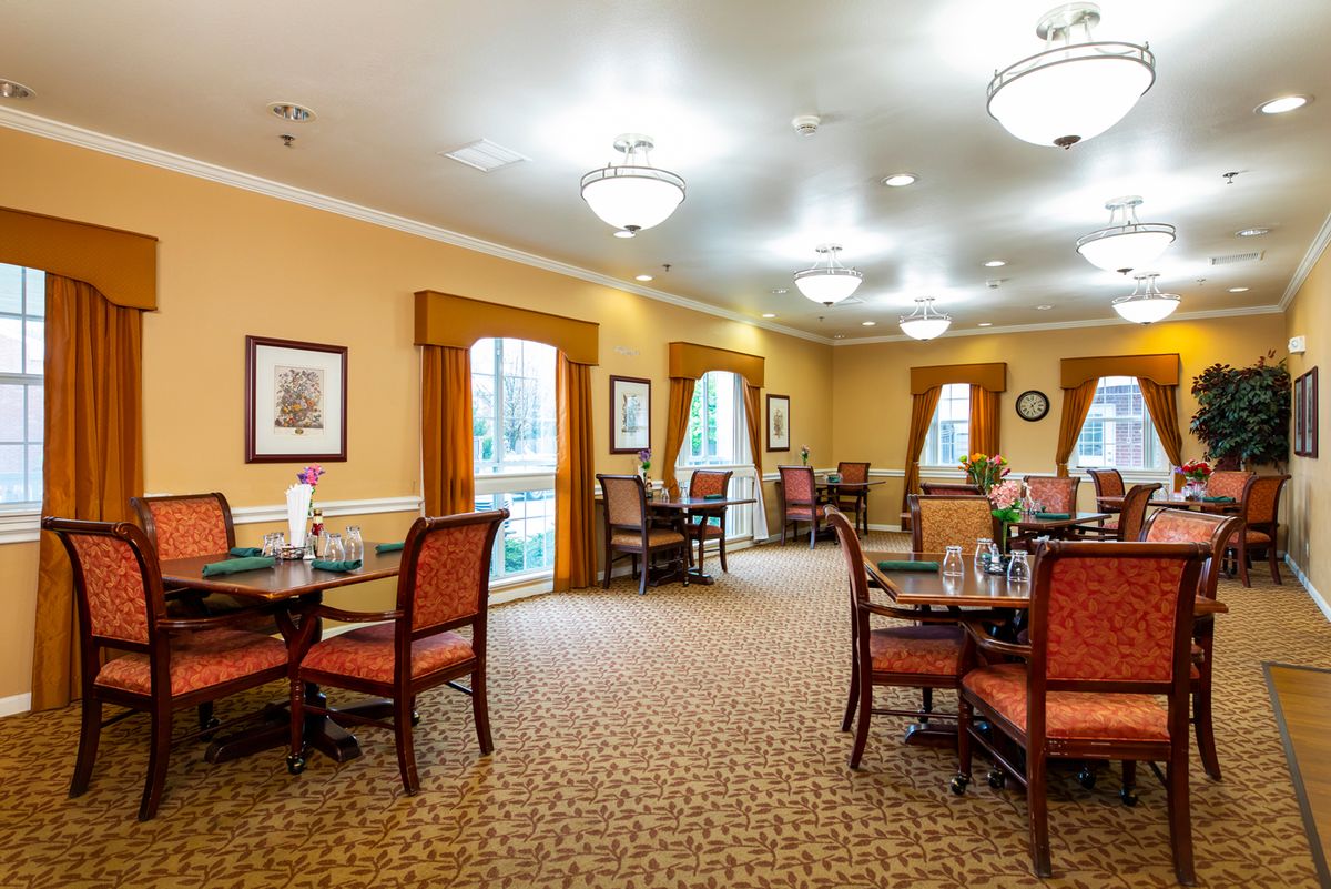 A well-lit dining area with elegant decor and neatly arranged tables and chairs.