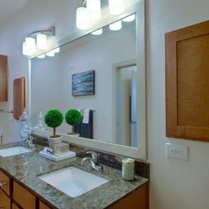 Modern bathroom with granite countertops and contemporary lighting.