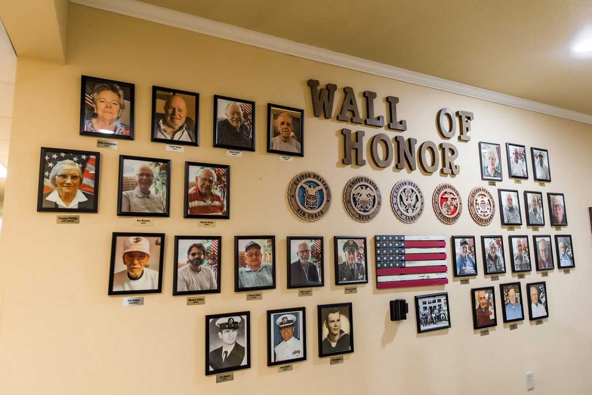 A Wall of Honor displaying photographs and emblems recognizing military veterans.