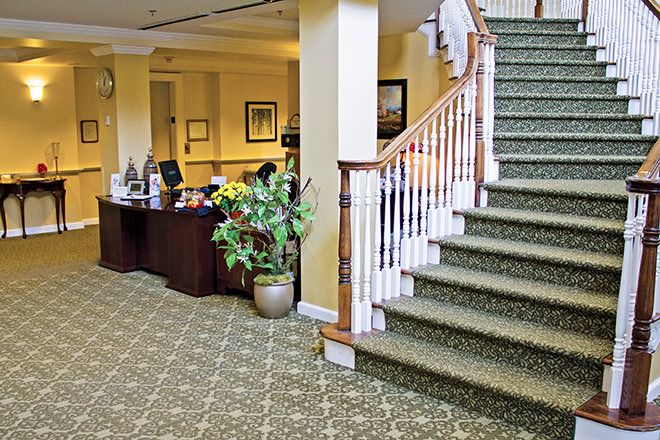 A lobby area with a reception desk and carpeted staircase.