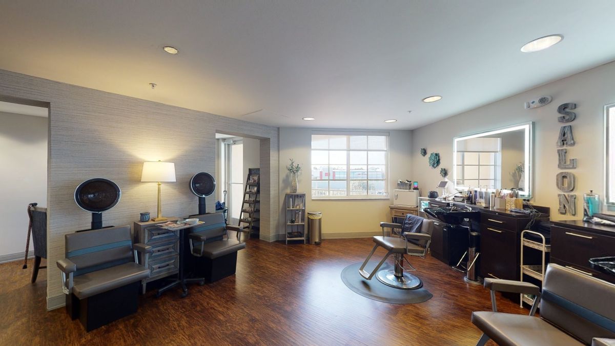 A modern and spacious hair salon interior with styling chairs and equipment.