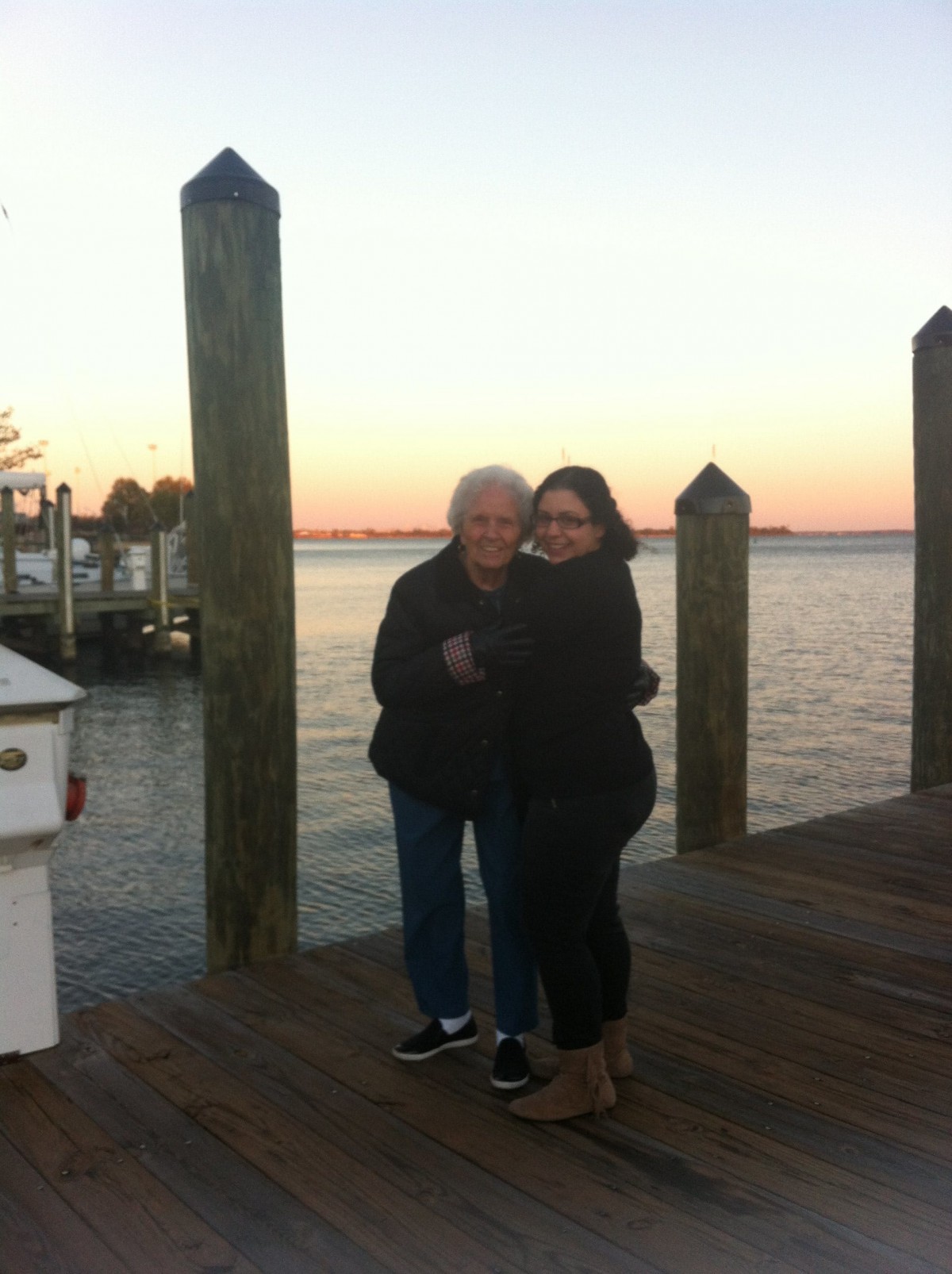 A warm embrace on a dock at sunset.