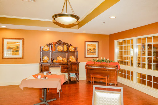 A cozy dining area featuring warm tones, elegant furniture, and a piano, perfect for gatherings.