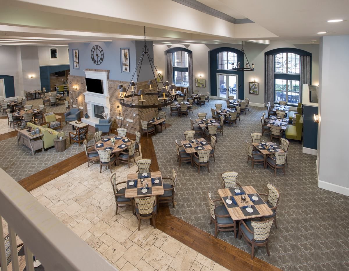 A spacious and elegantly decorated dining area with neatly arranged tables and chairs.