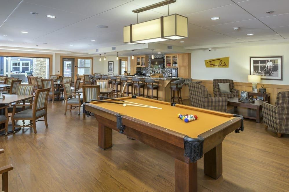 A recreational room featuring a pool table, comfortable seating, and modern lighting.