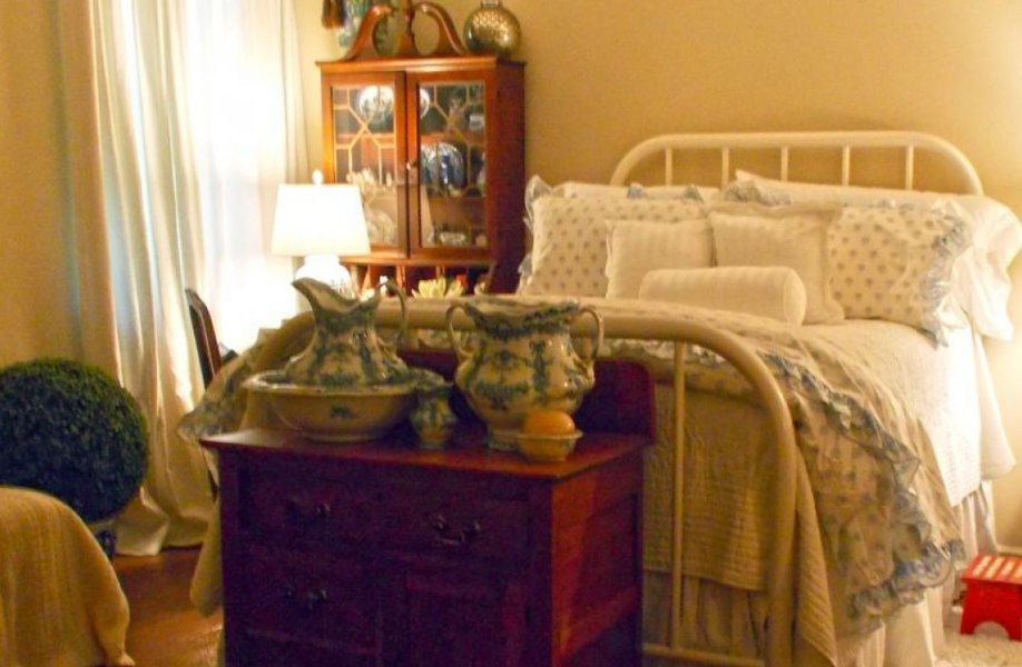 A vintage-style bedroom with antique furniture and decorative items.