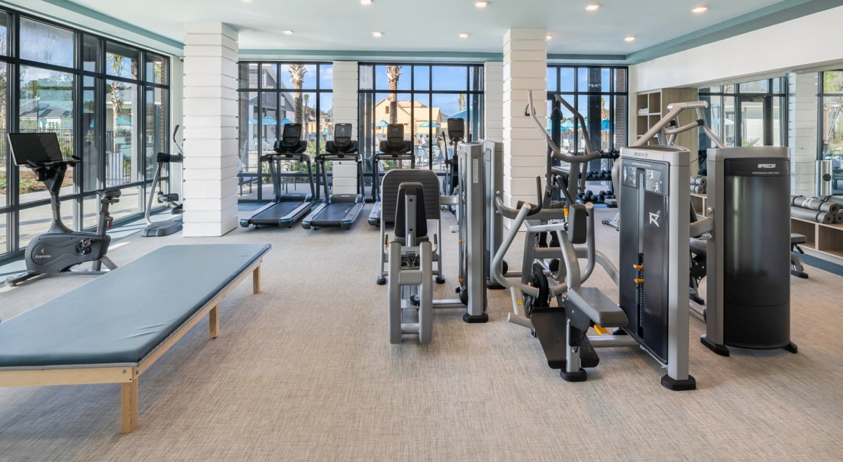 A modern gym with various exercise equipment, including treadmills and weight machines.