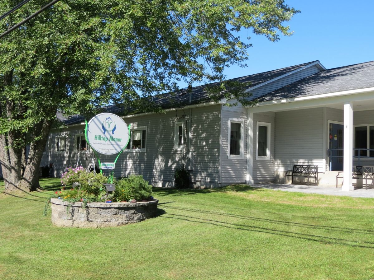 A house with a well-maintained lawn and a garden, featuring a satellite dish in the yard.