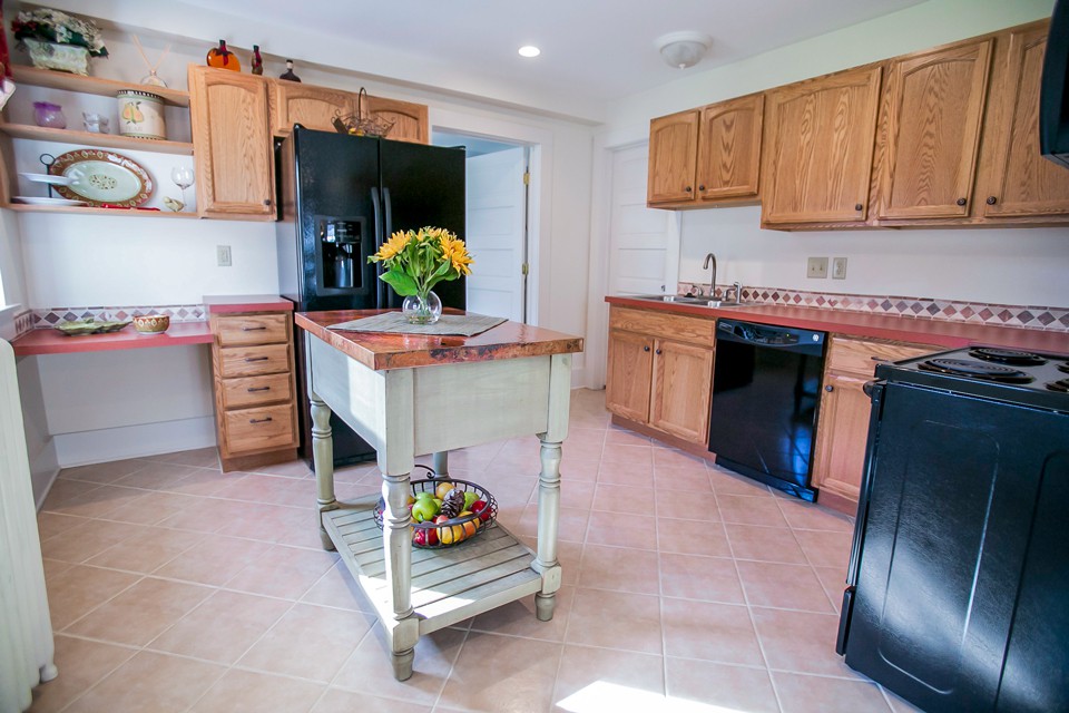 A modern kitchen with wooden cabinets, a central island, and contemporary appliances.
