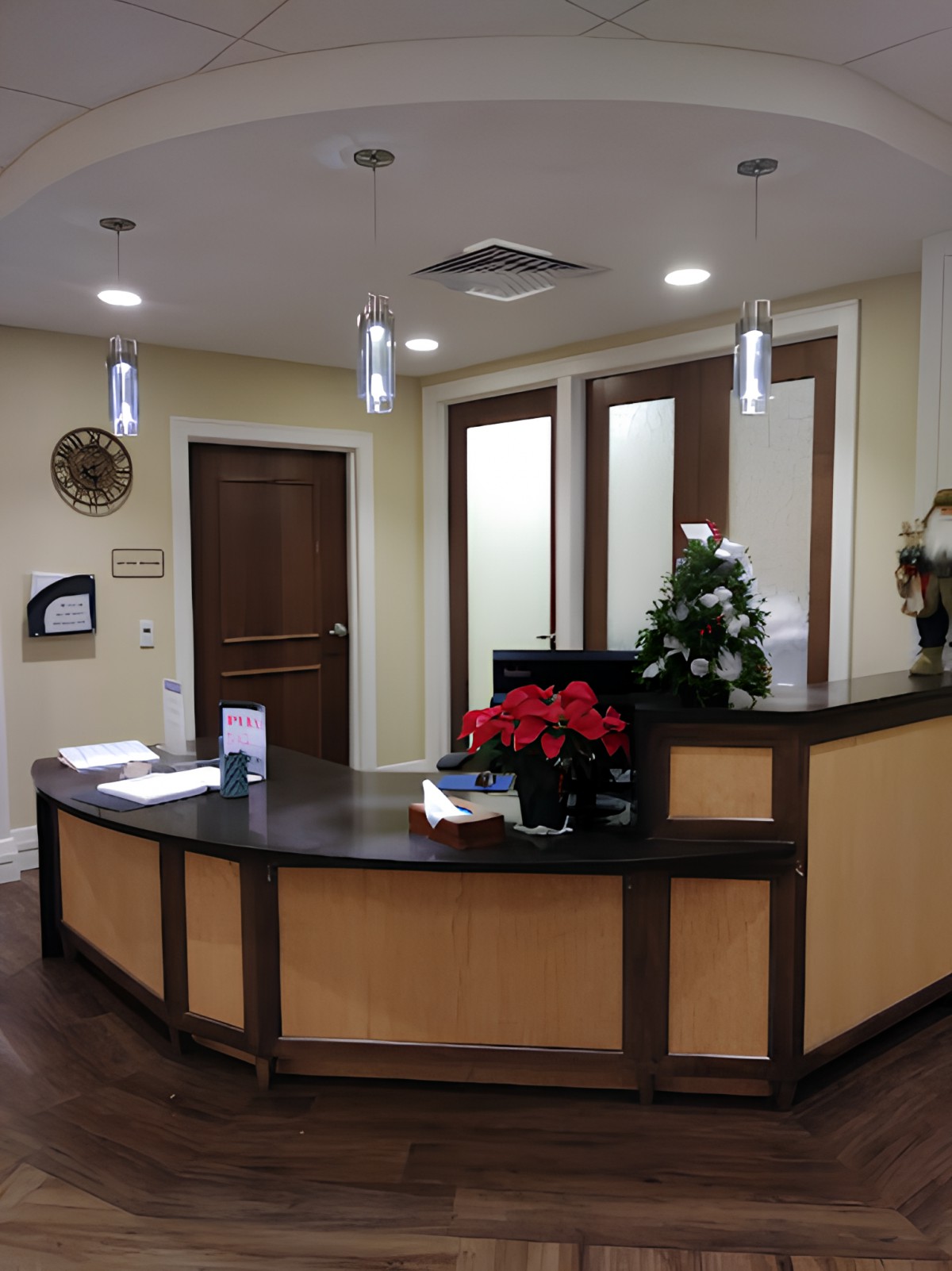 A reception area with a front desk and decorative plants.