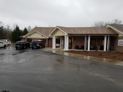A residential house with parked vehicles on a rainy day.