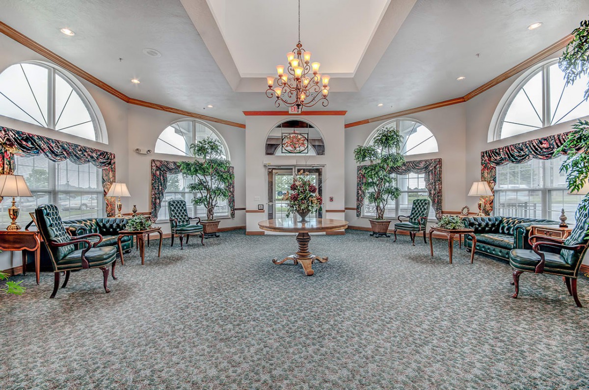 Elegant lobby with a central chandelier, seating area, and large windows.