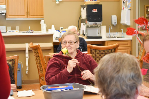 A cheerful resident engaging in a creative activity at a senior care facility.