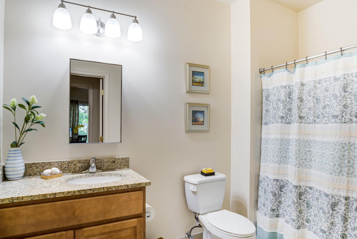 A neat and modern bathroom with a vanity, mirror, and shower.